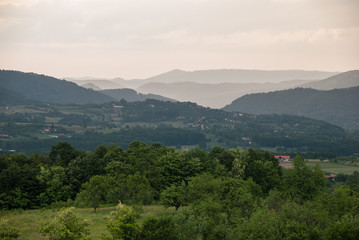 Rural forest landscape with high mountains in the background
