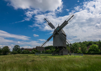 Fototapeta na wymiar The old windmill in a village against sky