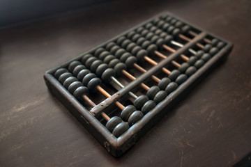 The old wooden abacus traditional of Chinese trade on wooden table