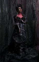 Dark queen in black fantasy costume on dark gothic background