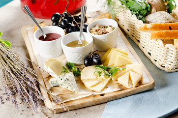 assorted cheeses with honey, jam, nuts and grapes