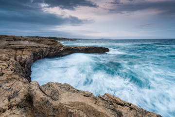 Fototapeta na wymiar Waves crasching at cliffs at Mediterranean Sea in Spain