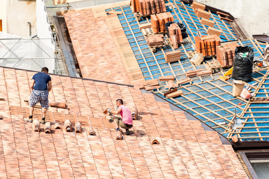 Construction site. Masons to work on the roof for laying tiles