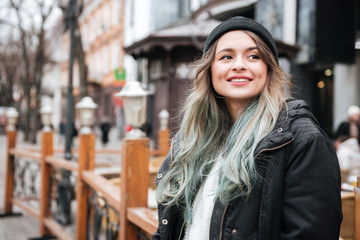 Pretty young lady wearing hat walking on the street