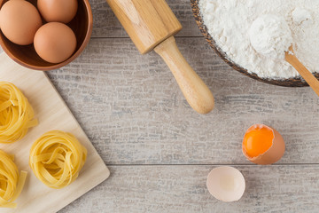 Raw homemade pasta and ingredients for pasta on wooden backgroun