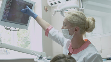 Dentist examining patient's teeth on the monitor