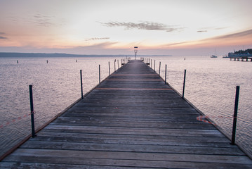 Fototapeta na wymiar Wooden pier entering into the sea with colorful morning sky