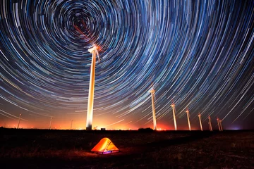 Foto op Aluminium Cirkels in de nachtelijke hemel / Nachtlandschap met langdurige blootstelling met stersporen boven een windmolenpark © Jess_Ivanova