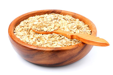Oat flakes in a wooden bowl with spoon.