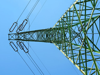 Green pole high voltage on the blue sky.