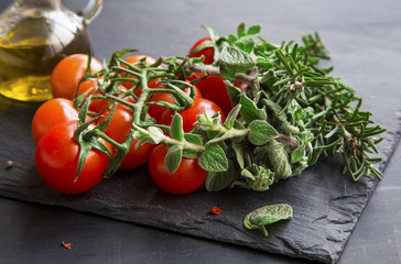 Cherry tomatoes with fresh oregano and rosemary herbs
