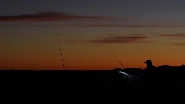 Silhouette eines Anglers im Sonnenuntergang am indischen Ozean in Fremantle, Perth, Westaustralien