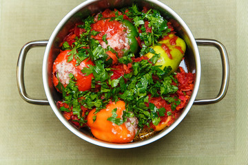 raw stuffed pepper with greens in pan.top view