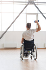 Athletic young invalid exercising with weights in the gym