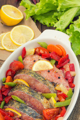 Sea bass with vegetables. marinated fish with vegetables for cooking in the oven. Wooden background. Top view. Close-up