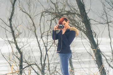 Young woman with camera in nature