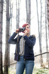 Young woman with camera in nature