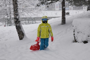 Fototapeta na wymiar bambini bambino giocare sulla neve sciare tuta da sci neve nevicata neve fresca 