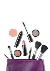 Aerial view of make up products spilling out of a purple leather cosmetics bag, isolated on a white...