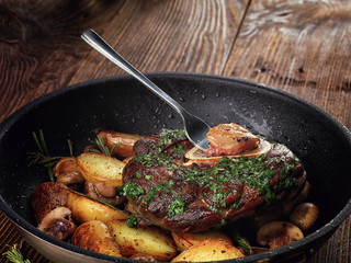 Fried ossobuco with vegetable ragout of potatoes and mushrooms.
