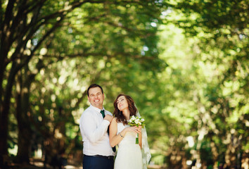 The smilling brides stands in the park