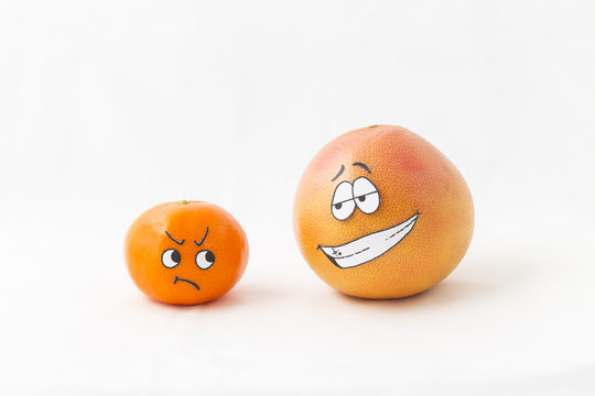 A big orange grapefruit and a tangerine with funny faces and white background