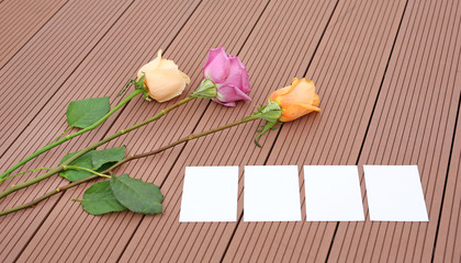 Empty notepaper and rose flower on wooden.
