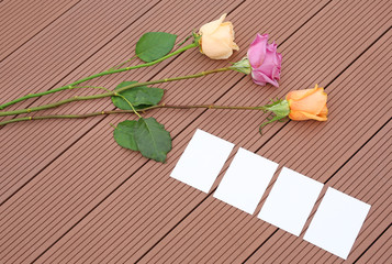 Empty notepaper with pink rose flower on wooden.