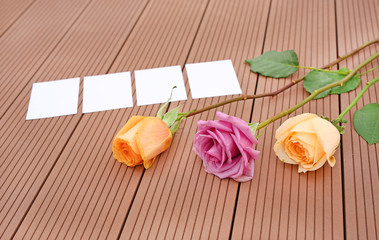 Empty notepaper with pink rose flower on wooden.