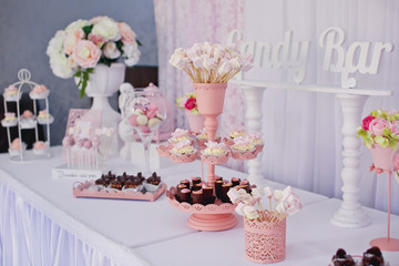 Candy bar. Dessert table for a party. Ombre cake, cupcakes, sweetness. 