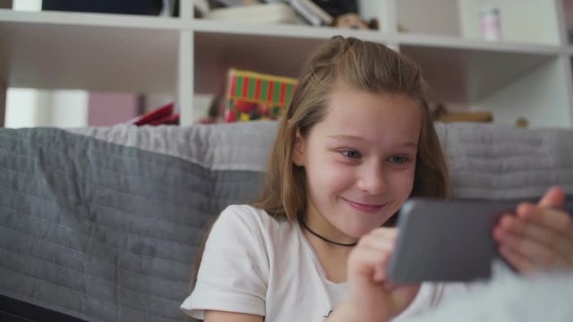 Little girl having fun with game in smartphone