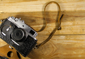 Old retro camera in leather case on wooden background
