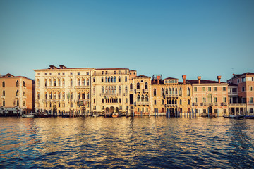 Fototapeta na wymiar Typical venetian buildings from the waterside of Grand Canal int the golden hour, Venice (Venezia), Italy, Europe, Vintage filtered style