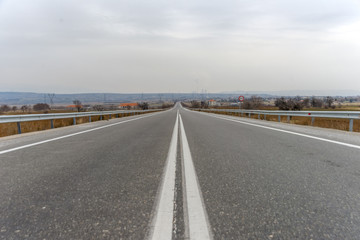 Long asphalt road. Mountains in the horizon... - 136308400