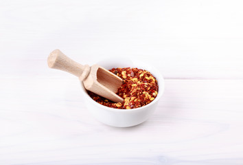 Red hot chili pepper flakes on white.