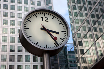 Fototapeta na wymiar Round urban clock on a pole in Canary Wharf, London