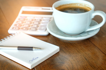 Concept,Coffee cup and notebook with calculator on wooden.