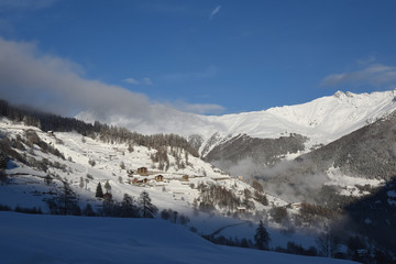 Fototapeta na wymiar paese di montagna con neve nevicata nevica case di montagna monti inverno freddo
