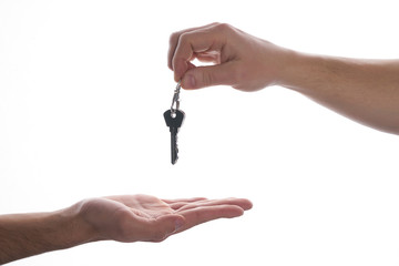 One hand giving key to another on isolated white background. Process of buying renting selling. Agreement between two people about sales purchase.
