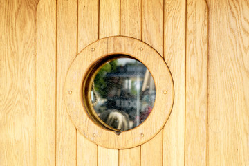 Ship window or porthole on wooden wall