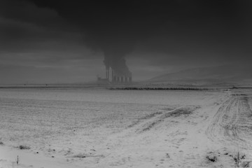 Power plant with smoking chimneys. Mountains in the background.. - 136311401