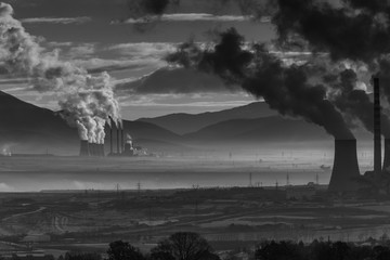 Power plant with smoking chimneys. Mountains in the background.. - 136311462