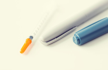 close up of injection pen and insulin syringe