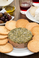 pate with toasts on white plate, olives, oil and red wine
