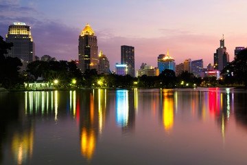 Fototapeta na wymiar Business district cityscape from a park with twilight time from lumpini park, Bangkok Thailand