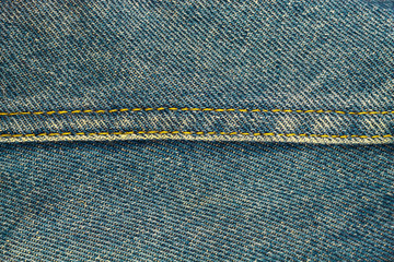 Blue jeans with seam, denim texture background, close up.