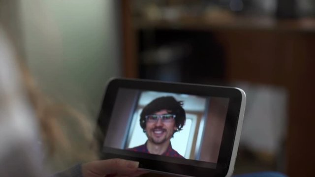 Man and woman communicate through video chat on tablet