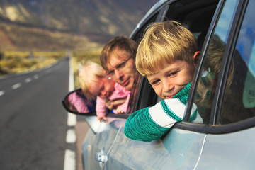 family travel by car- happy father with kids in mountains