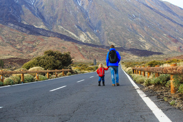 father with little daughter walking on road