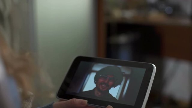 Man and woman communicate through video chat on tablet